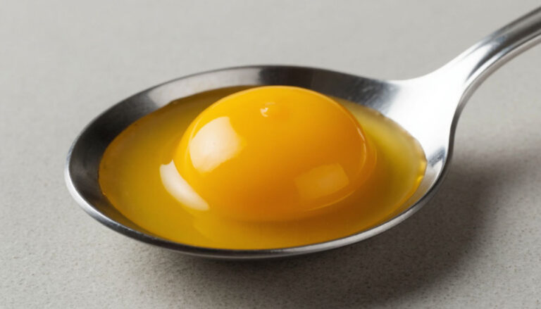 Яркий яичный желток в ложке крупным планом