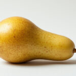 Спелая средняя груша на светлом фоне