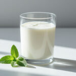 Стакан свежего кефира 1% жирности на светлом фоне