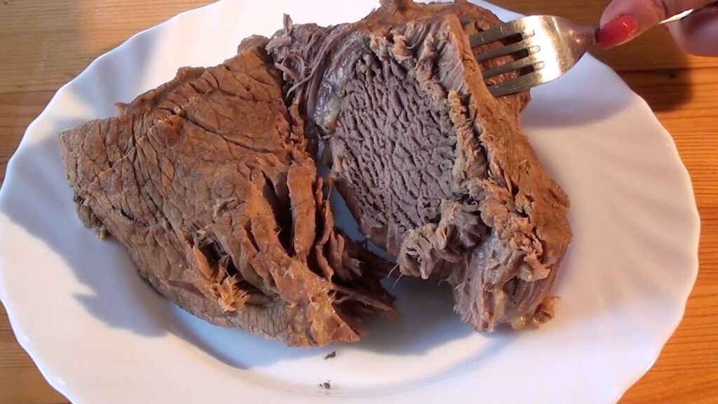 Отварная говядина нарезанная ломтиками на белой тарелке