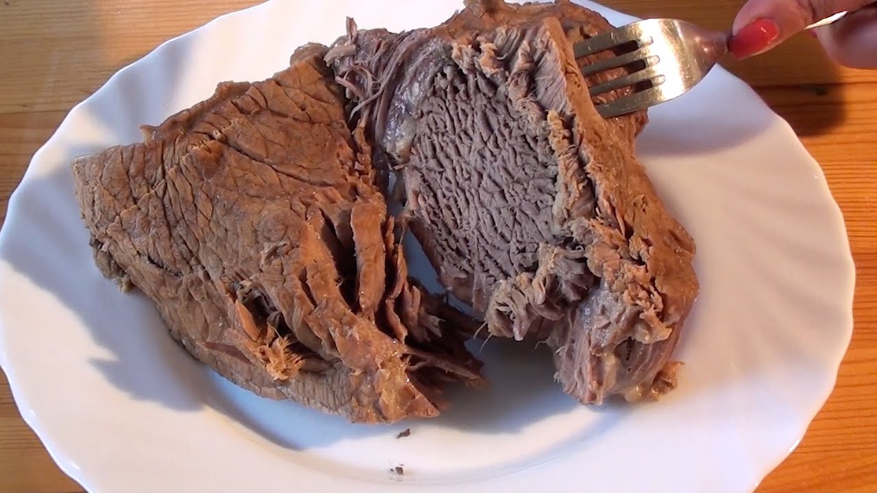 Отварная говядина нарезанная ломтиками на белой тарелке