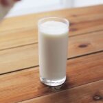 Стакан густой ряженки на деревянном столе