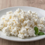 Свежий рассыпчатый творог 5 процентов жирности в тарелке