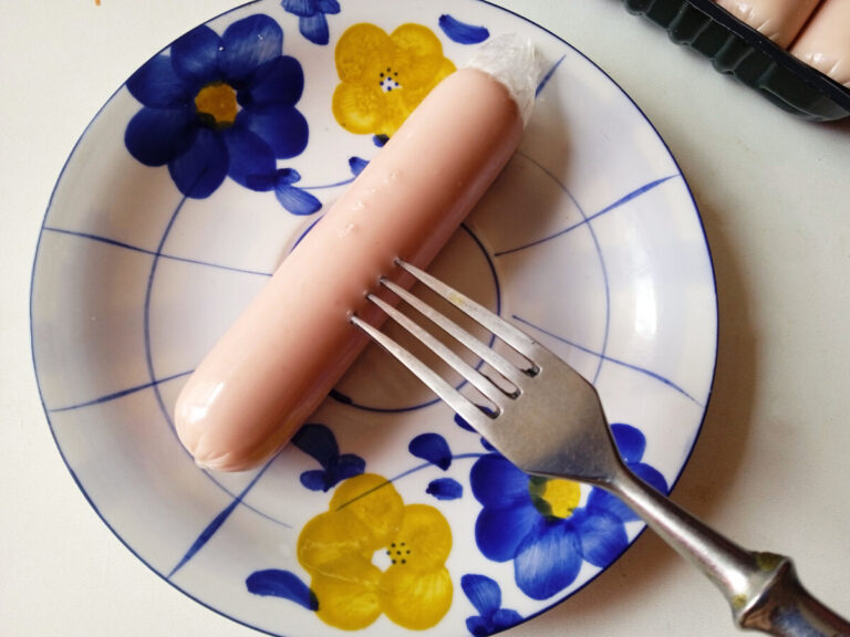 Вареная сосиска на вилке