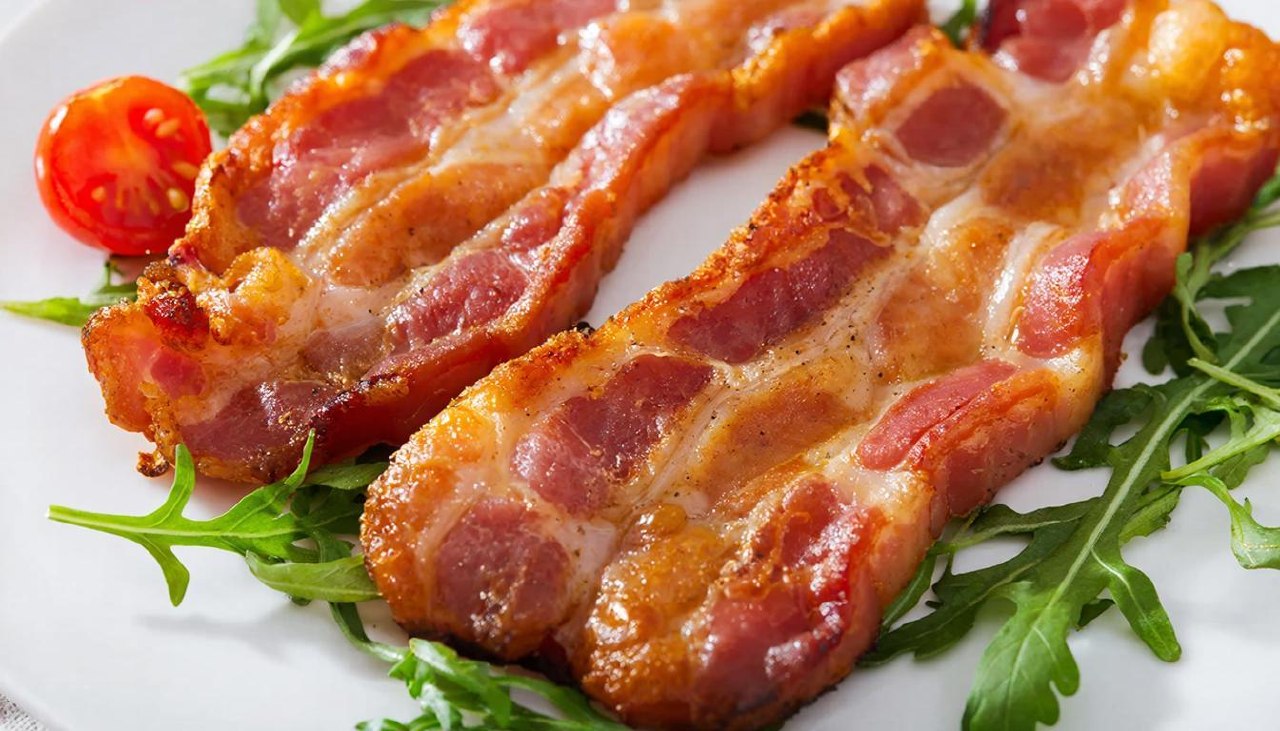 Поджаренные ломтики бекона на тарелке для подсчета калорий
