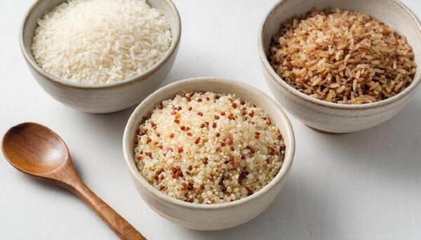 Сравнение зерен белого риса бурого риса и киноа в тарелках