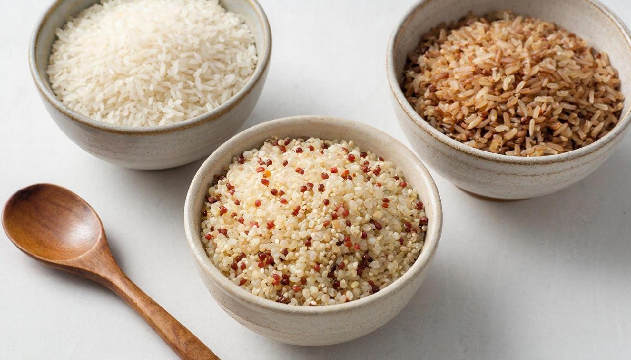 Сравнение зерен белого риса бурого риса и киноа в тарелках
