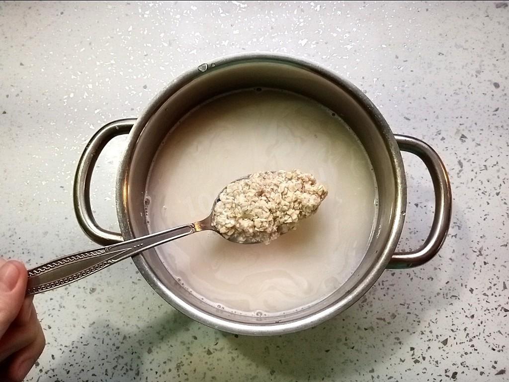 Столовая ложка с готовой овсяной кашей на воде крупным планом