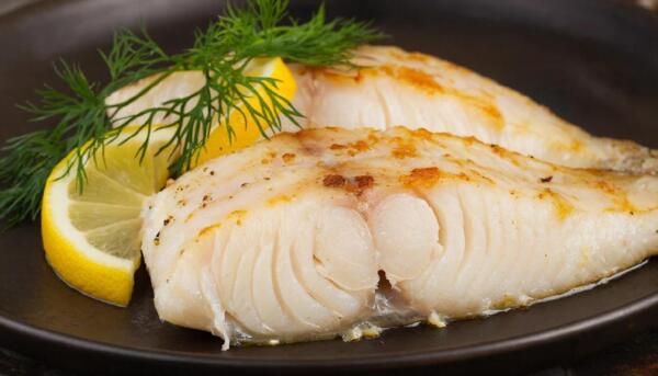 Запеченная долька филе минтая на тарелке с лимоном