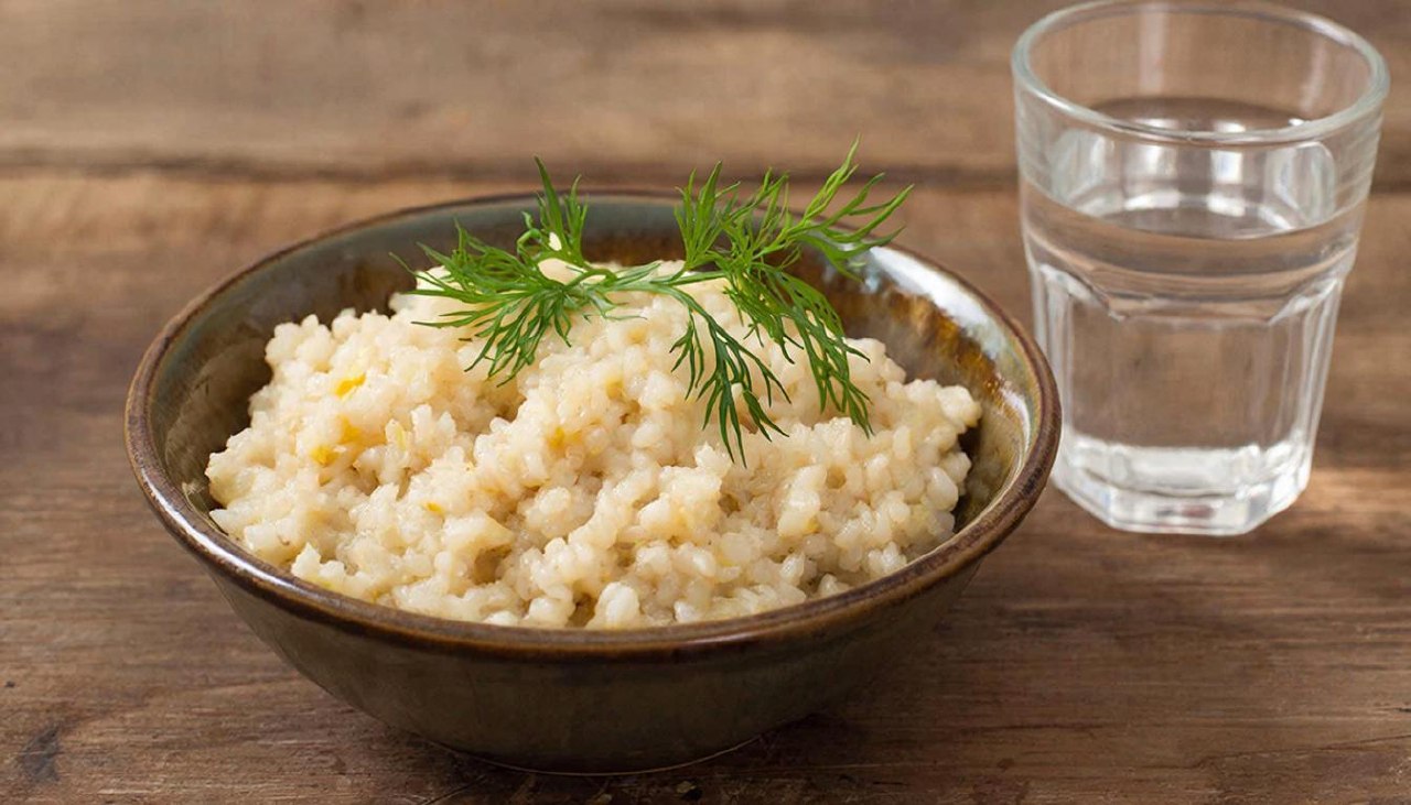 Порция вареной перловой каши на воде в тарелке для расчета калорий