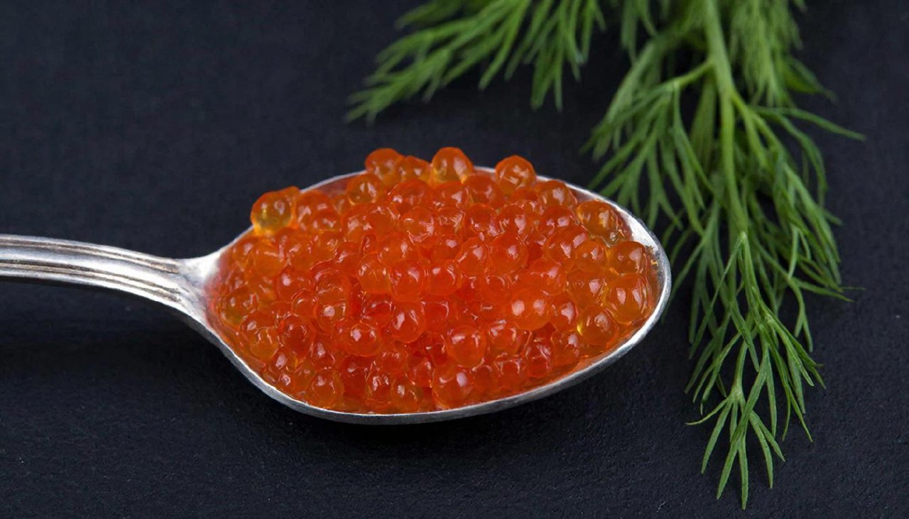 Красная икра в серебряной ложке крупным планом для расчета калорий